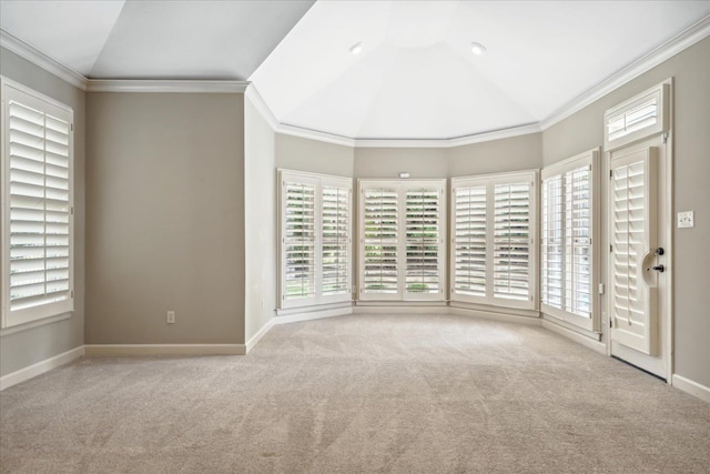 carpeted empty room with lofted ceiling, a healthy amount of sunlight, and crown molding