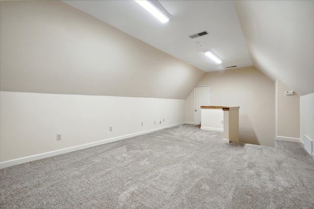 additional living space featuring lofted ceiling and light colored carpet