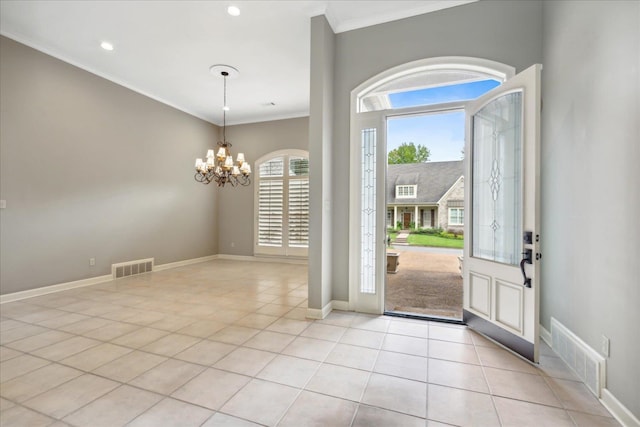 tiled foyer entrance with an inviting chandelier and ornamental molding