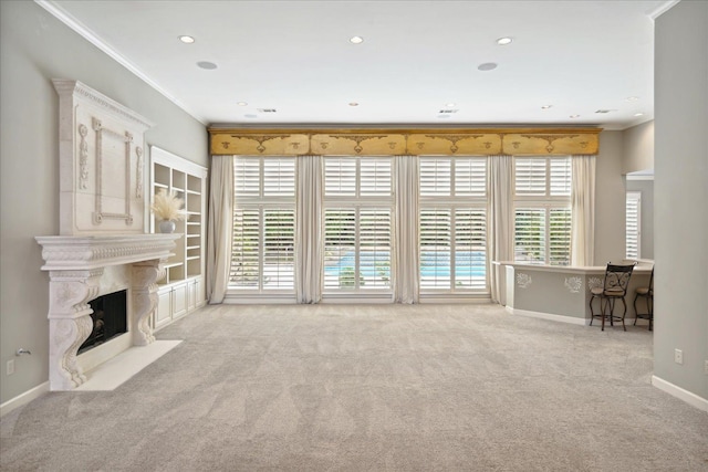 unfurnished living room with light colored carpet, crown molding, a premium fireplace, and plenty of natural light