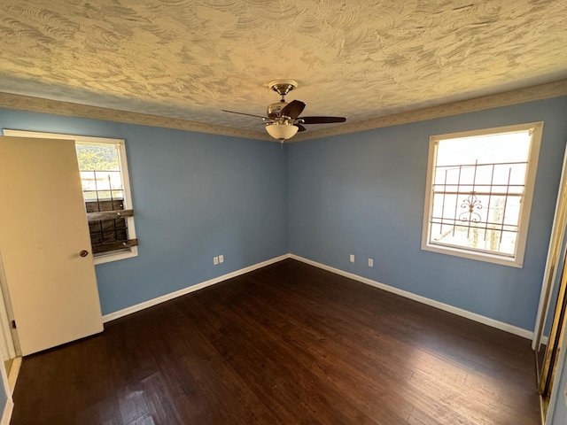 unfurnished room with baseboards, a textured ceiling, dark wood-type flooring, and ceiling fan