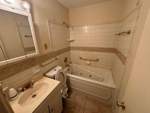 full bath with tile patterned floors, vanity, toilet, tile walls, and a combined bath / shower with jetted tub