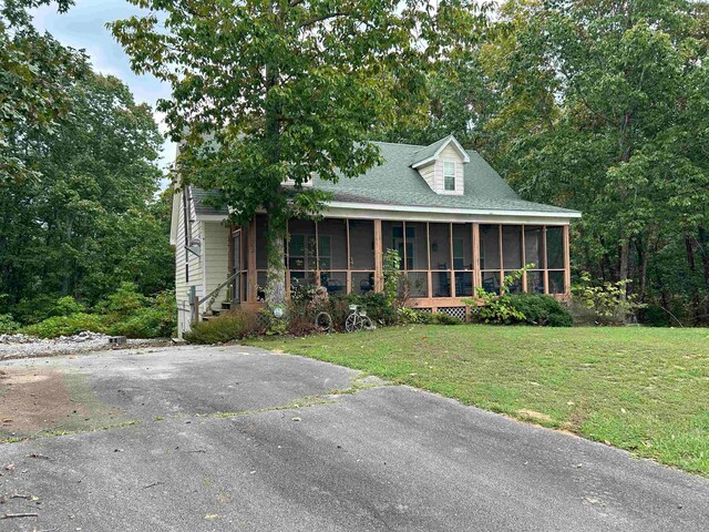 view of front of house with a sunroom and a front yard