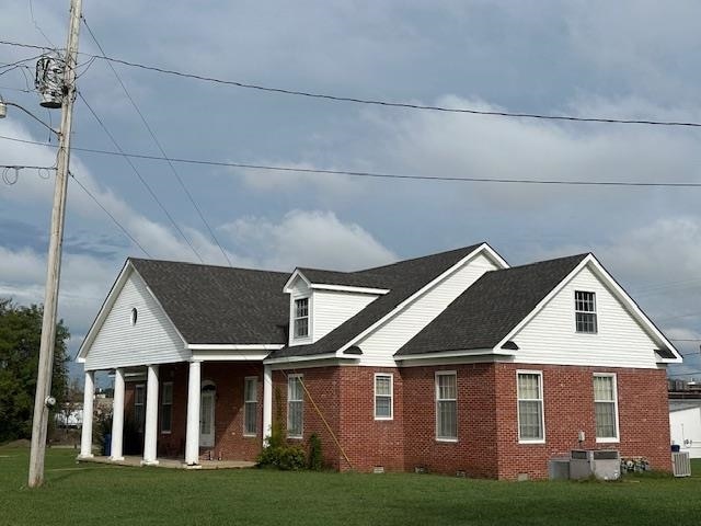 view of front of home featuring a front yard and central air condition unit