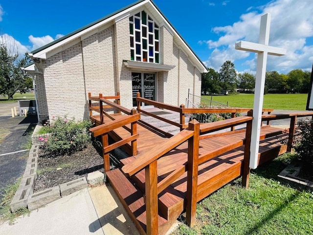 back of house featuring a lawn and a wooden deck