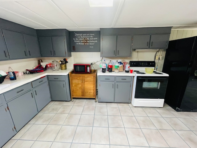 kitchen featuring black appliances, backsplash, and gray cabinets