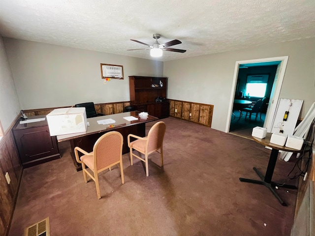 interior space featuring ceiling fan, carpet flooring, and a textured ceiling