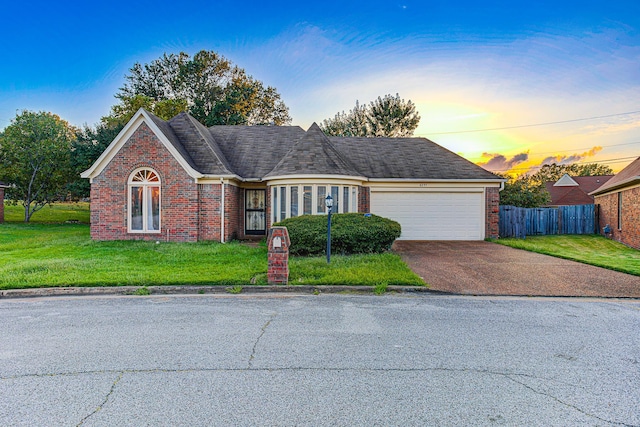 view of front facade with a garage and a yard