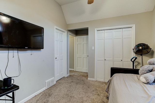 carpeted bedroom with ceiling fan and vaulted ceiling