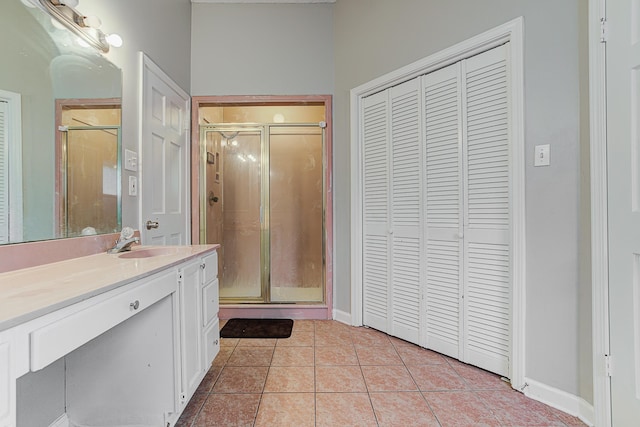 bathroom featuring tile patterned flooring, walk in shower, and vanity