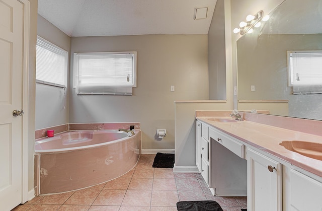 bathroom with lofted ceiling, vanity, tile patterned floors, a bath, and a textured ceiling