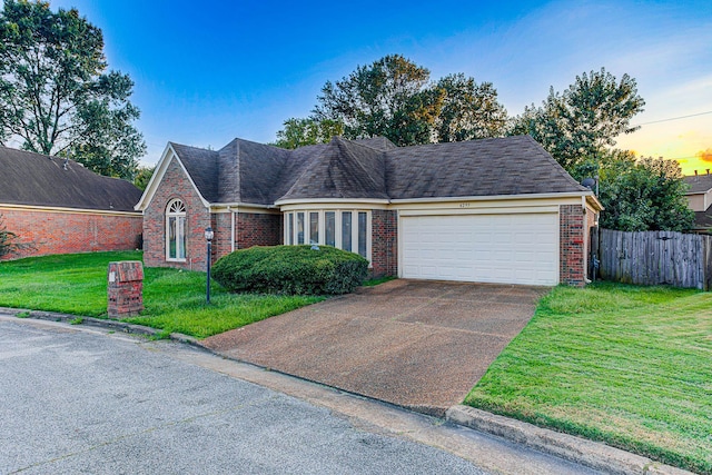 view of front facade featuring a garage and a lawn