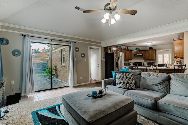 tiled living room featuring ceiling fan, vaulted ceiling, crown molding, and a textured ceiling