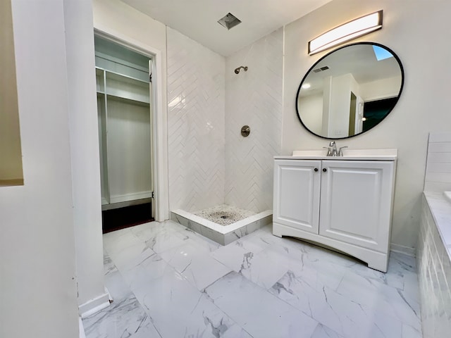 bathroom featuring a tile shower and vanity