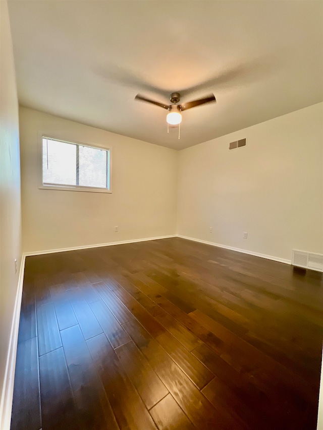 unfurnished room with ceiling fan and dark wood-type flooring