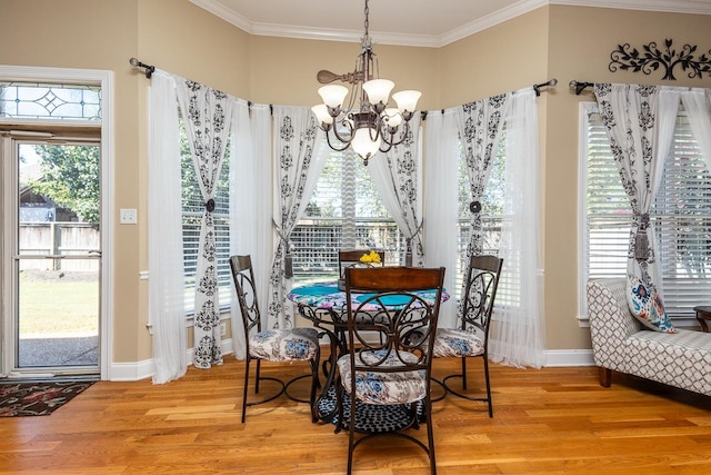 dining area with a notable chandelier, hardwood / wood-style floors, and crown molding