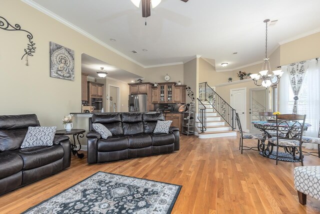 living room with light hardwood / wood-style flooring, ceiling fan with notable chandelier, and ornamental molding