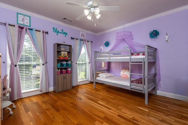 bedroom with ornamental molding, hardwood / wood-style floors, and ceiling fan