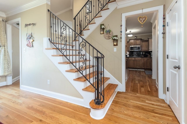 stairs featuring ornamental molding and hardwood / wood-style flooring