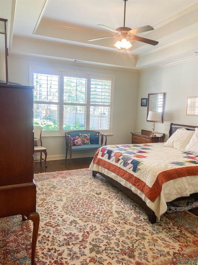 bedroom featuring ceiling fan, a raised ceiling, and multiple windows