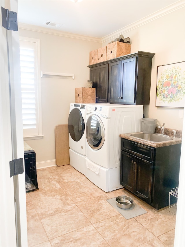 laundry room featuring light tile patterned flooring, cabinets, washing machine and clothes dryer, crown molding, and sink