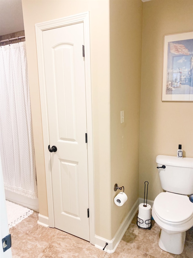 bathroom with curtained shower, tile patterned floors, and toilet