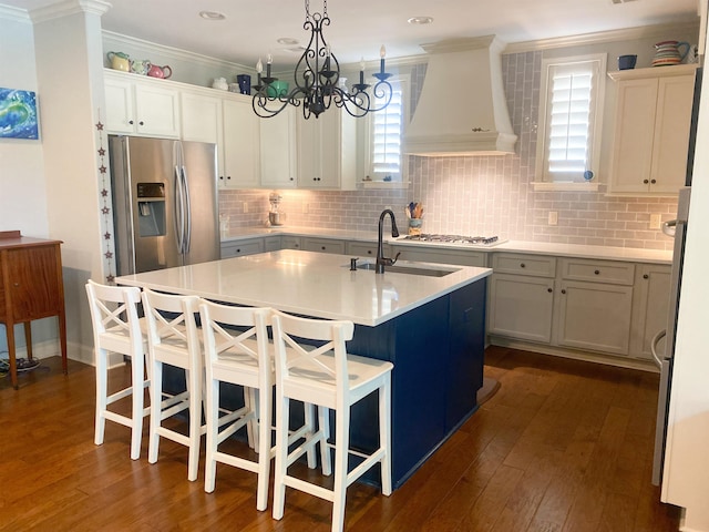 kitchen featuring an island with sink, dark wood-type flooring, sink, custom exhaust hood, and appliances with stainless steel finishes