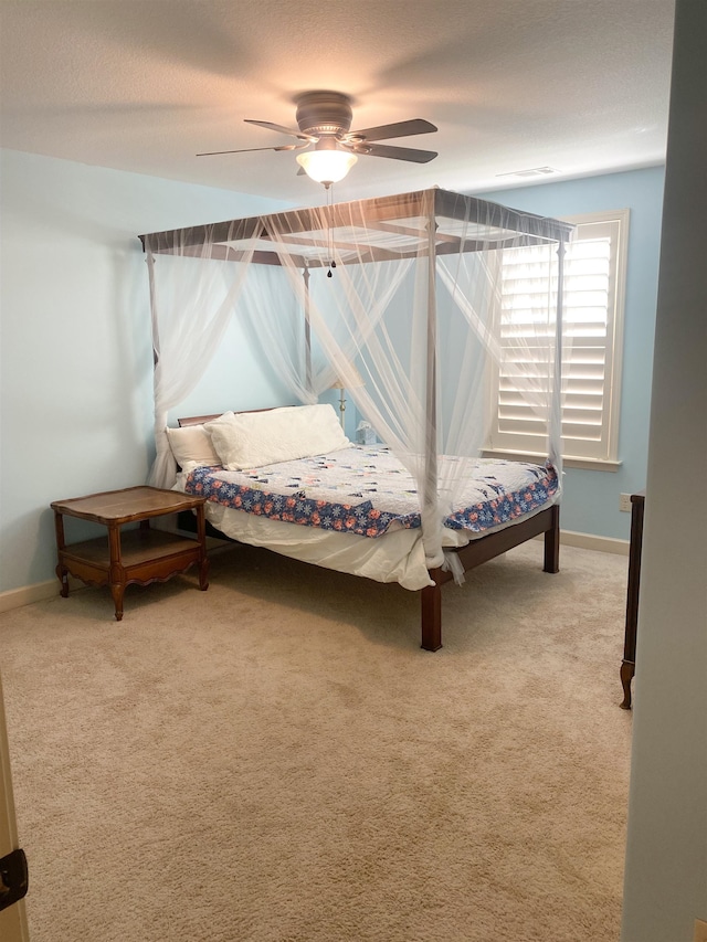 bedroom featuring ceiling fan, carpet floors, and a textured ceiling