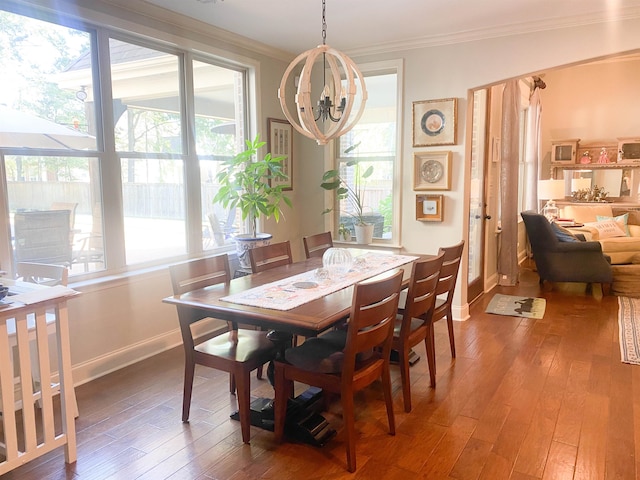 dining room with crown molding, hardwood / wood-style floors, an inviting chandelier, and a healthy amount of sunlight