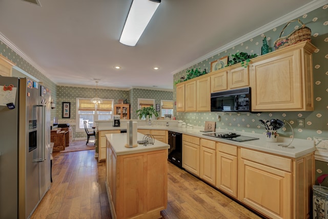 kitchen with kitchen peninsula, decorative light fixtures, light hardwood / wood-style flooring, black appliances, and a center island