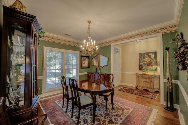 dining area with light hardwood / wood-style flooring, a chandelier, and ornamental molding