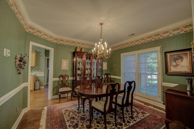 dining room featuring ornamental molding, a notable chandelier, and hardwood / wood-style floors