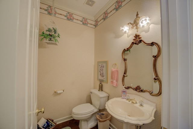 bathroom with hardwood / wood-style floors, ornamental molding, toilet, and sink