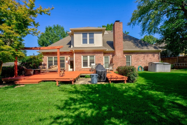 rear view of house with a deck and a yard