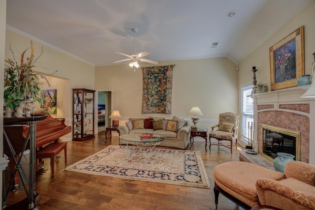 living room with ceiling fan, hardwood / wood-style flooring, a fireplace, crown molding, and vaulted ceiling