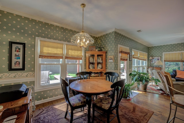 dining room featuring a notable chandelier, dark wood-type flooring, and crown molding