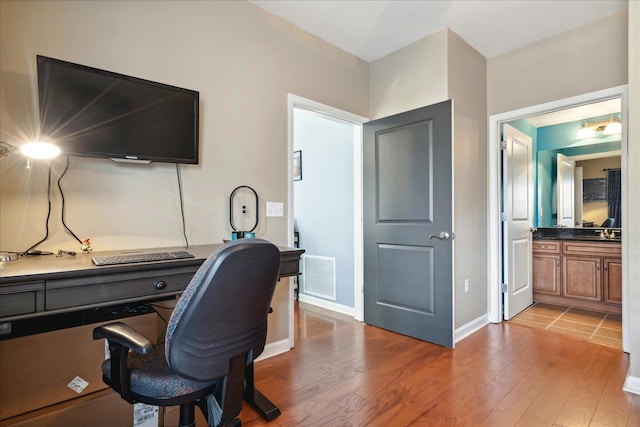 office with built in desk and light hardwood / wood-style floors