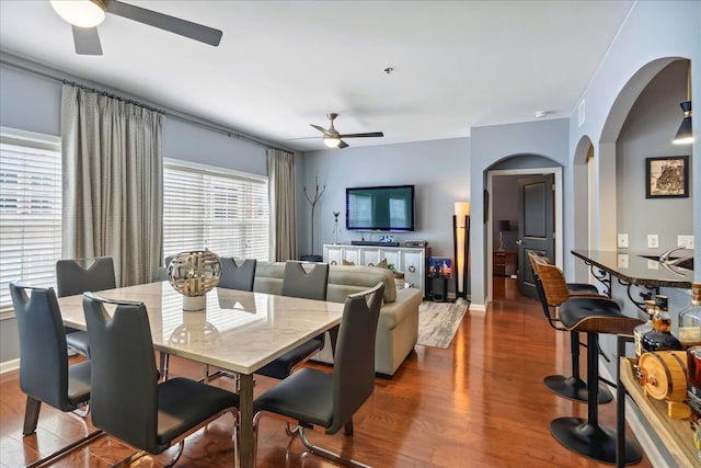 dining area with ceiling fan and dark wood-type flooring