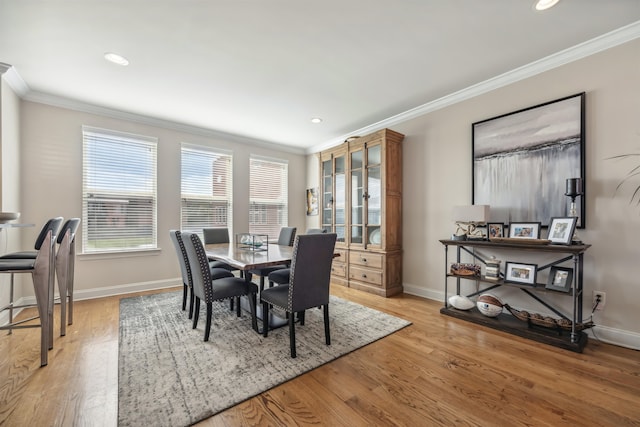 dining area featuring crown molding and light hardwood / wood-style flooring