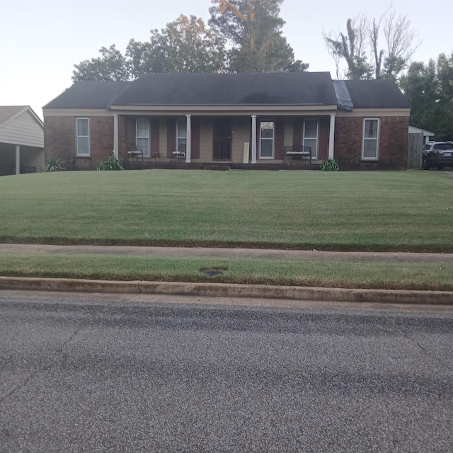 single story home with a porch and a front lawn