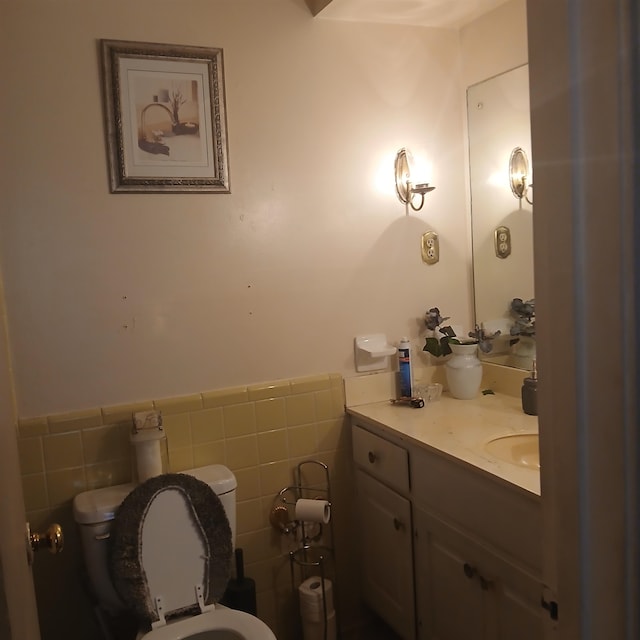 bathroom with tile walls, vanity, and toilet