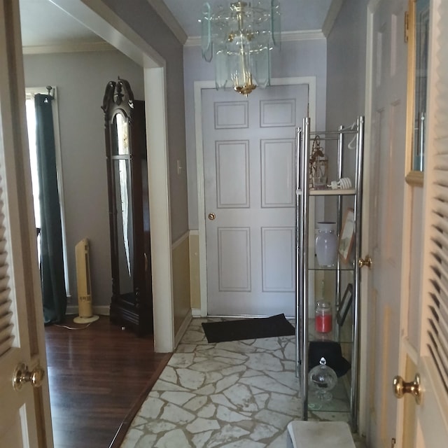 foyer with crown molding, dark wood-type flooring, and a chandelier