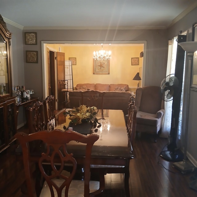 dining area featuring ornamental molding, hardwood / wood-style flooring, and an inviting chandelier