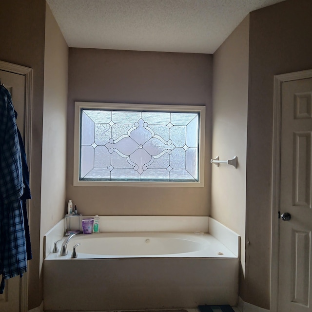 bathroom featuring a textured ceiling and a washtub