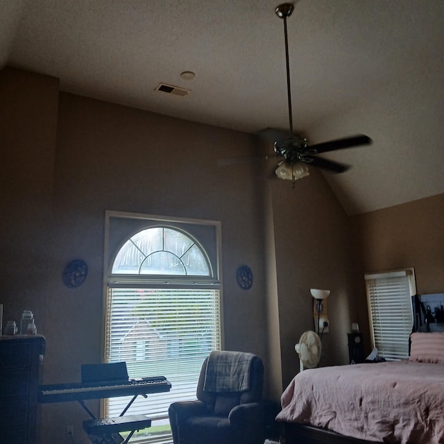 bedroom featuring ceiling fan, a textured ceiling, and vaulted ceiling