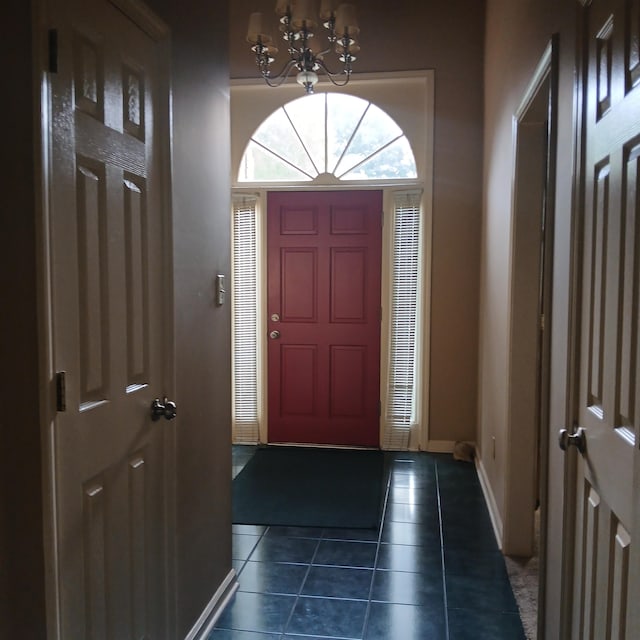 tiled entryway featuring an inviting chandelier