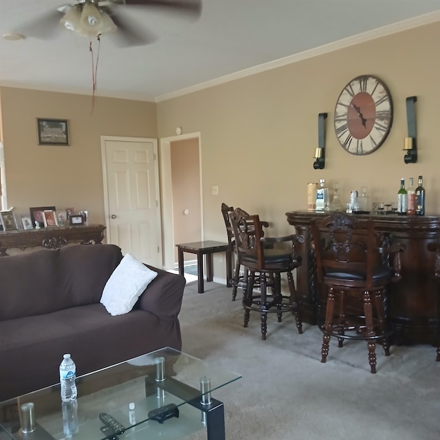 carpeted living room featuring ornamental molding, ceiling fan, and bar