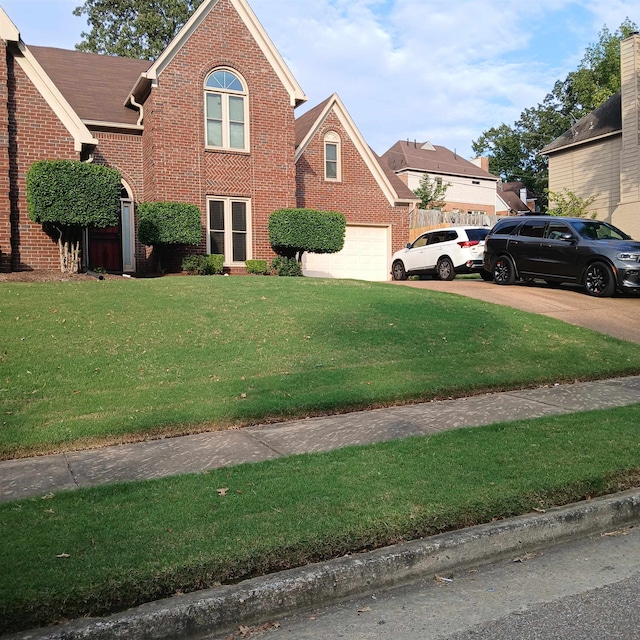 front of property with a garage and a front lawn