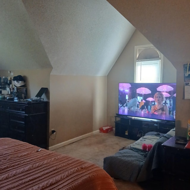 carpeted bedroom with a textured ceiling and vaulted ceiling