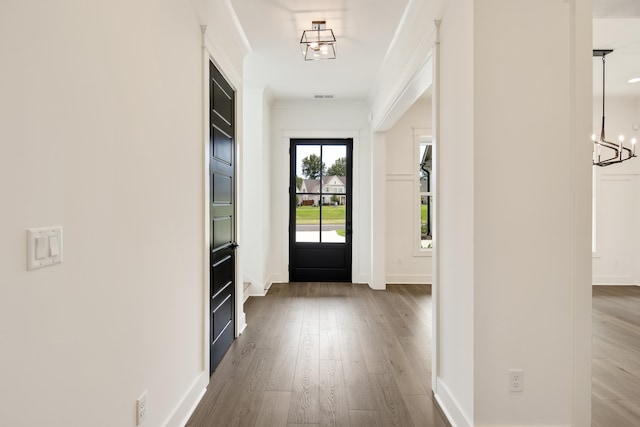 doorway featuring hardwood / wood-style floors and a chandelier